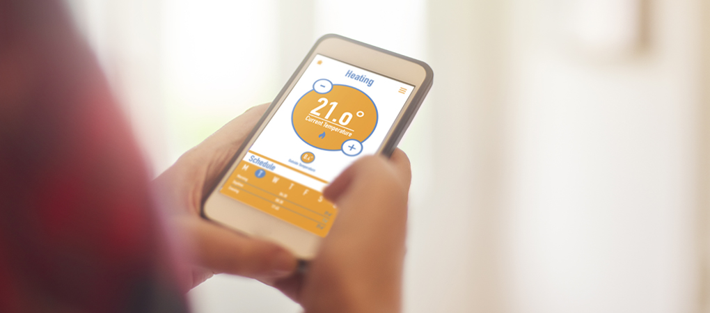 Portland homeowner adjusting the temperature and heating of their HVAC using a smartphone